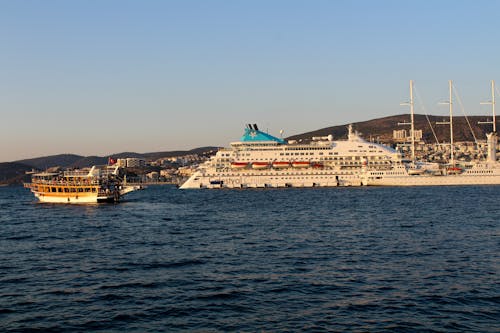 A Ferry Boat Sailing Near Cruise Ship on the Sea