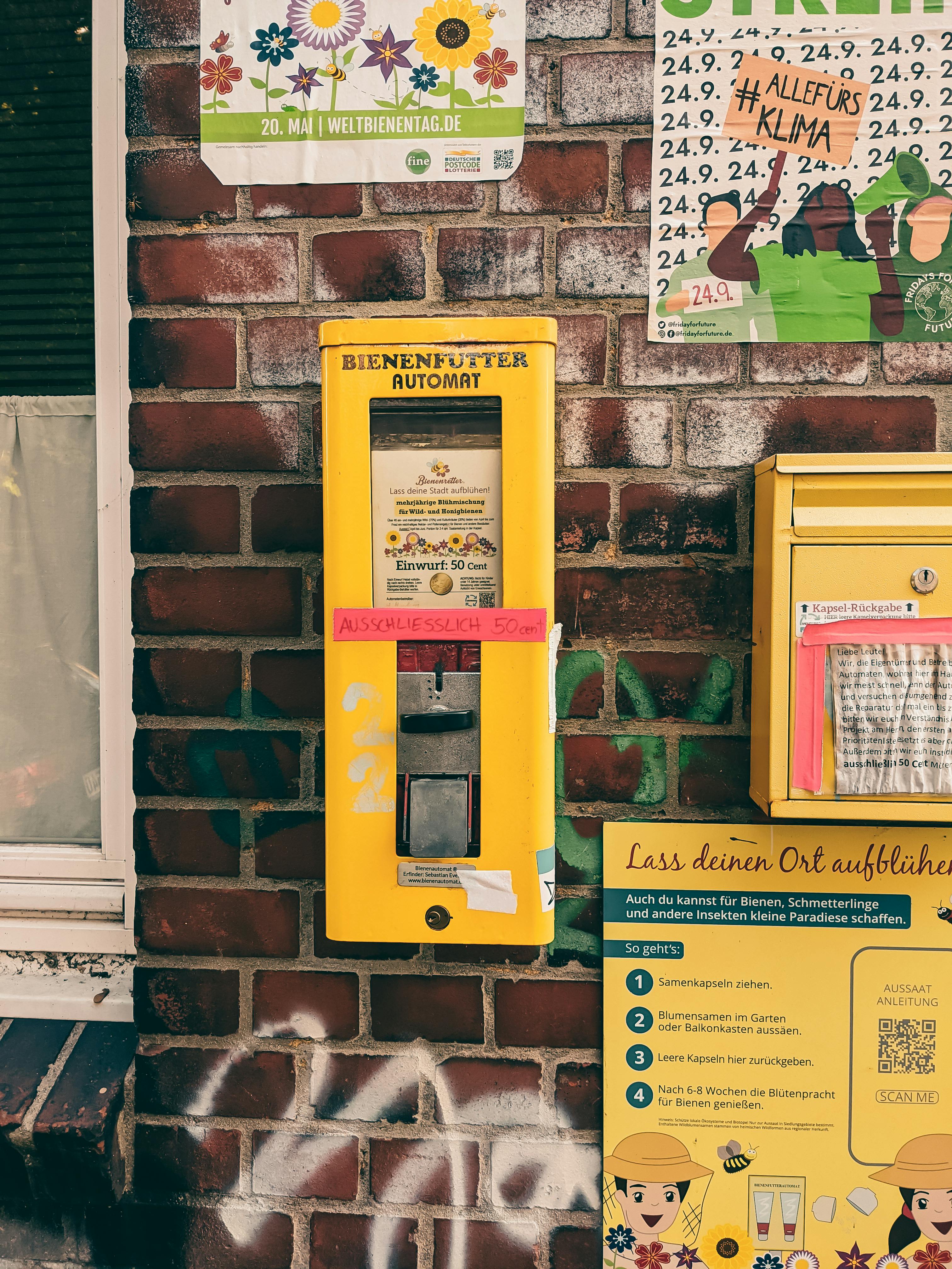 brick wall with a ticket machine and posters