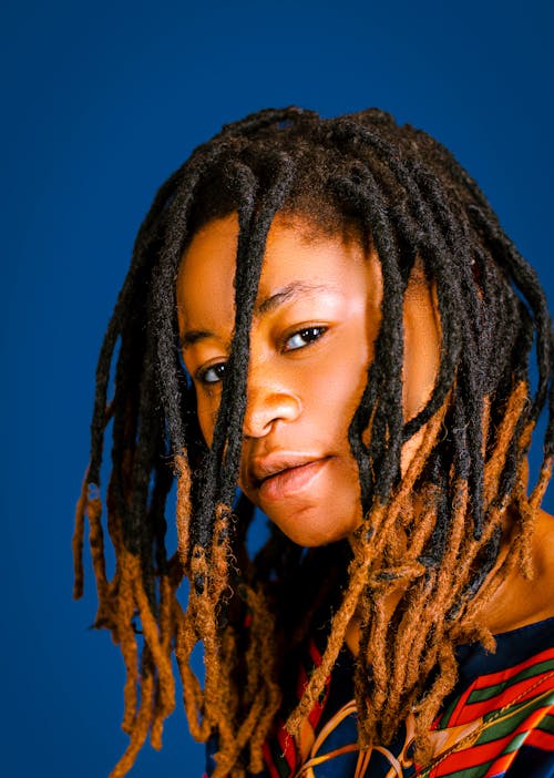 Woman with Dreadlocks Against Blue Background