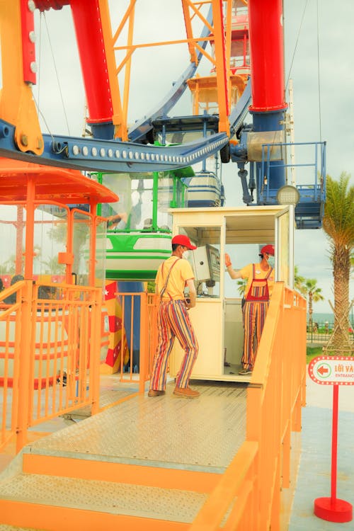 Colour Enhanced Photo of a Ferris Wheel with Staff Wearing Striped Trousers