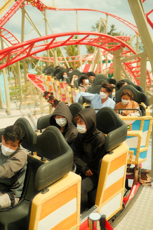 People Sitting in Wagons of Amusement Park Ride