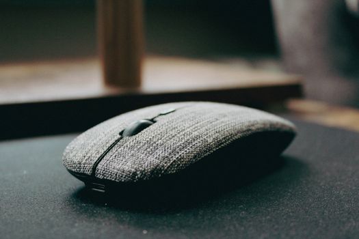 Close-up of a stylish wireless computer mouse with a fabric cover, showcasing modern design.