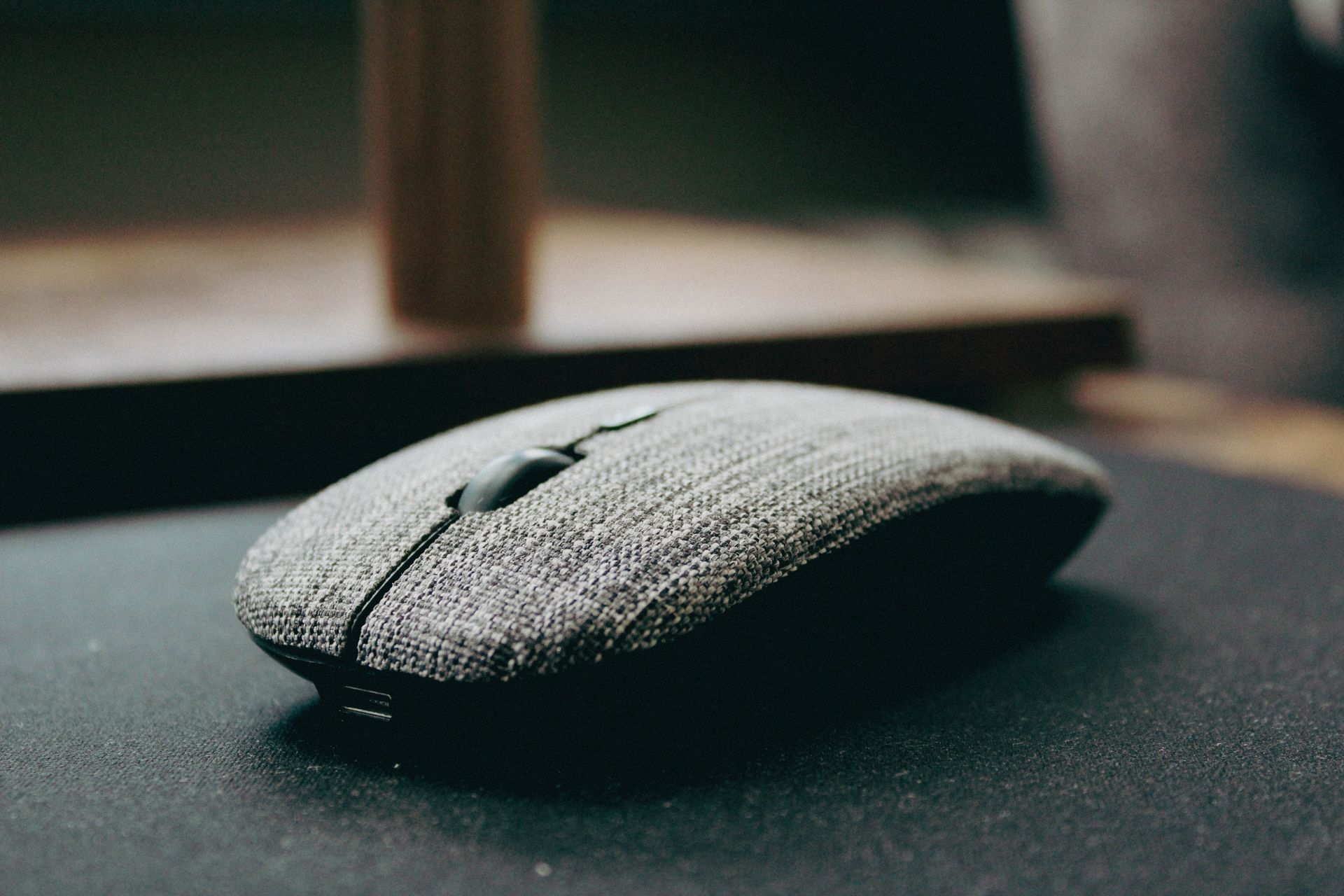 Close-up of a stylish wireless computer mouse with a fabric cover, showcasing modern design.