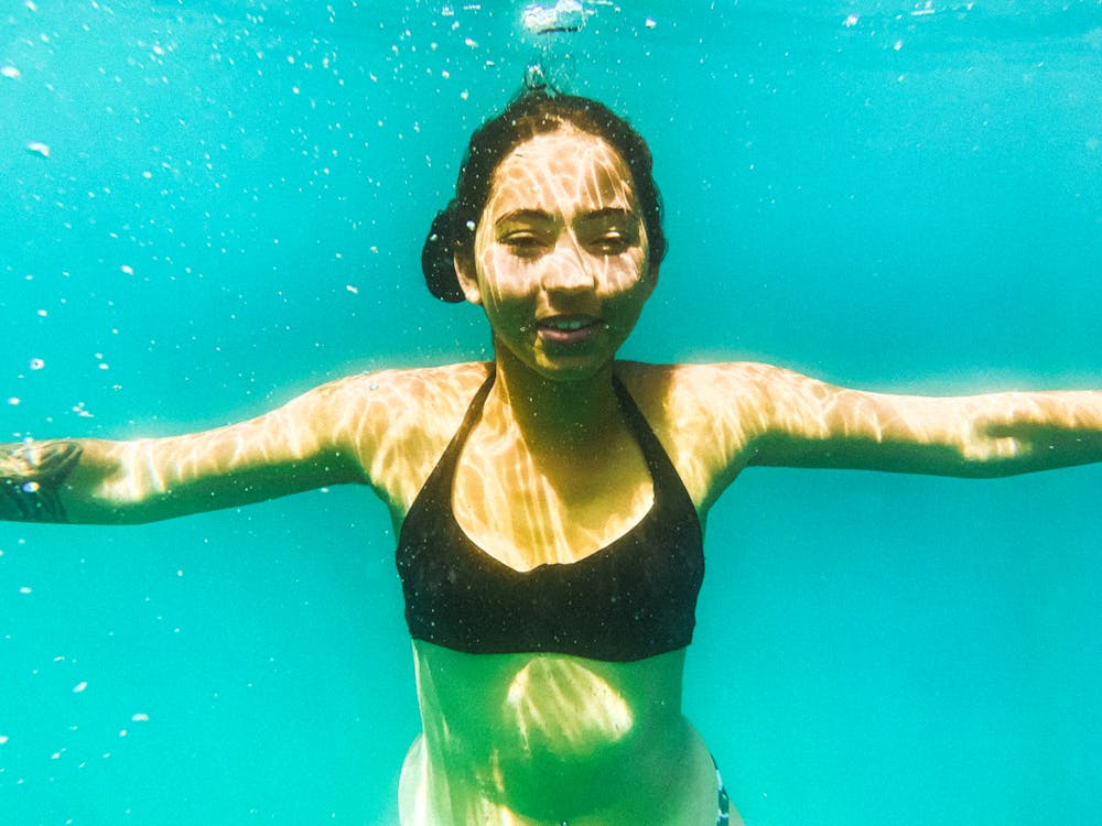 Underwater Photo of a Young Woman in a Black Bikini Smiling 