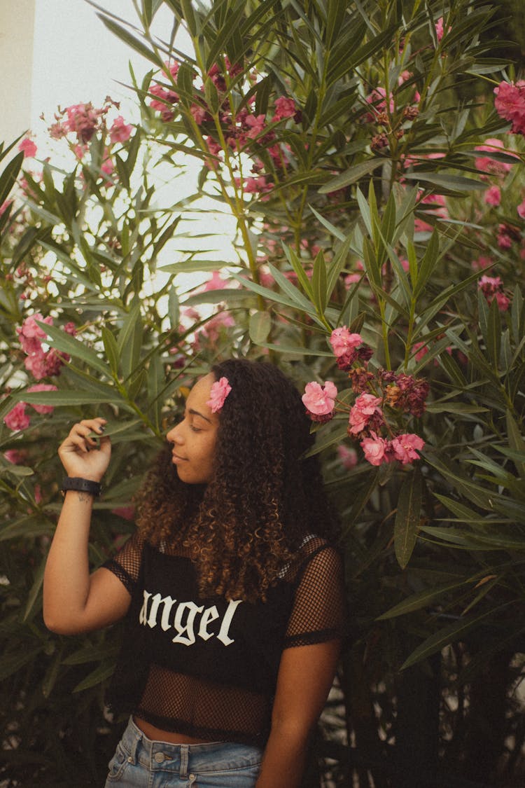 Portrait Of A Young Woman Wearing A Laced Crop Top Standing In Front Of Flowering Trees