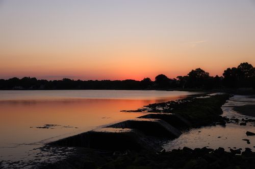 Free Peaceful sunset scene at a lake in Stamford, CT capturing placid waters and a dramatic twilight sky. Stock Photo
