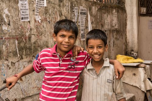 Free Two cheerful boys smiling and embracing in a vibrant street of Delhi, India. Stock Photo