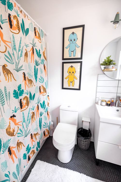 Free Bright and playful bathroom design with vibrant shower curtain and art prints. Stock Photo