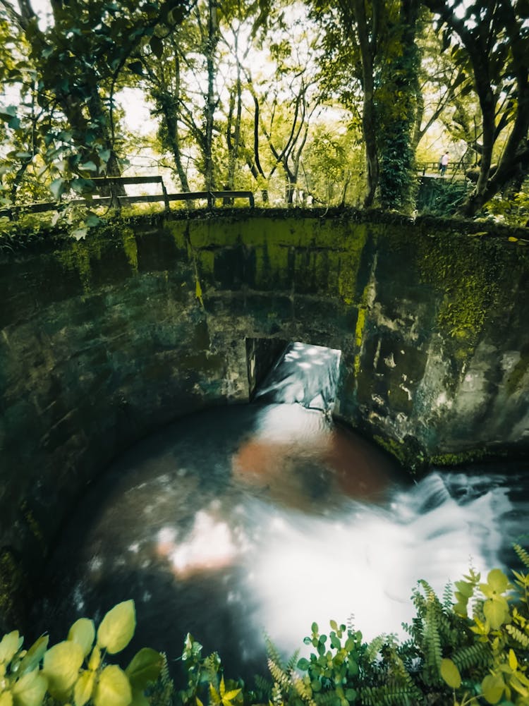 Photo Of A River Flowing Into An Old Small Dam