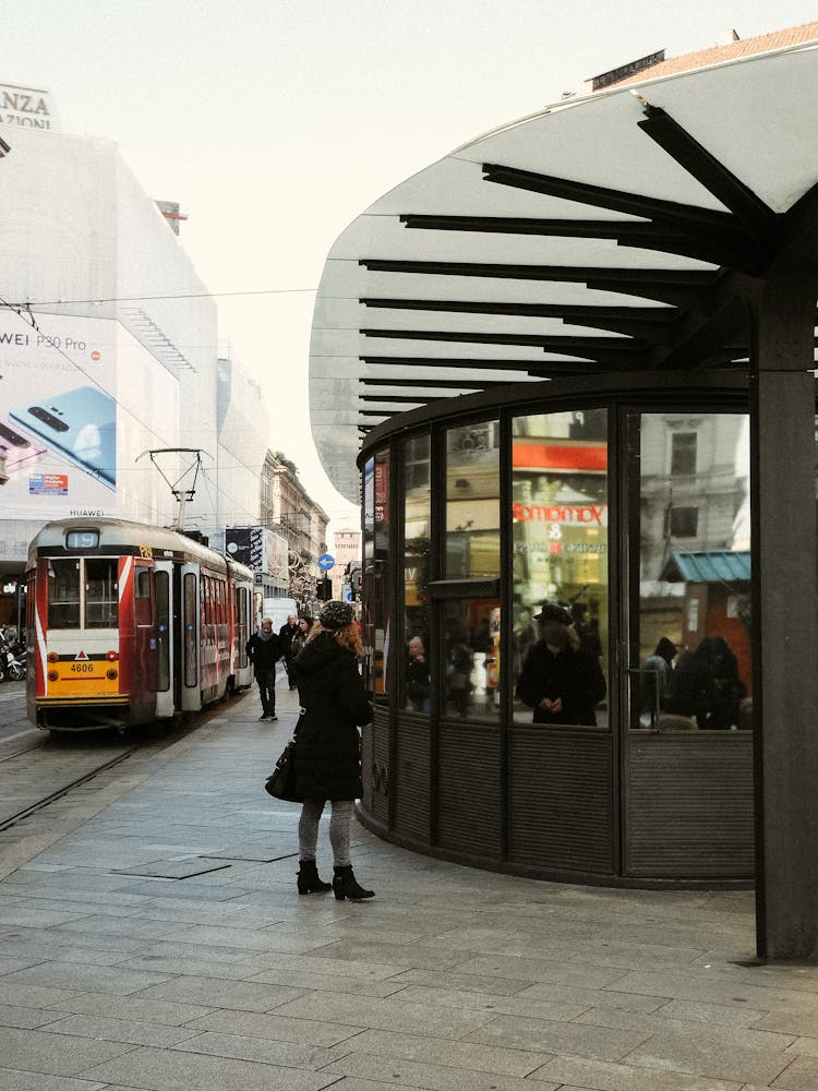 People Walking On Sidewalk Near Red And White Train