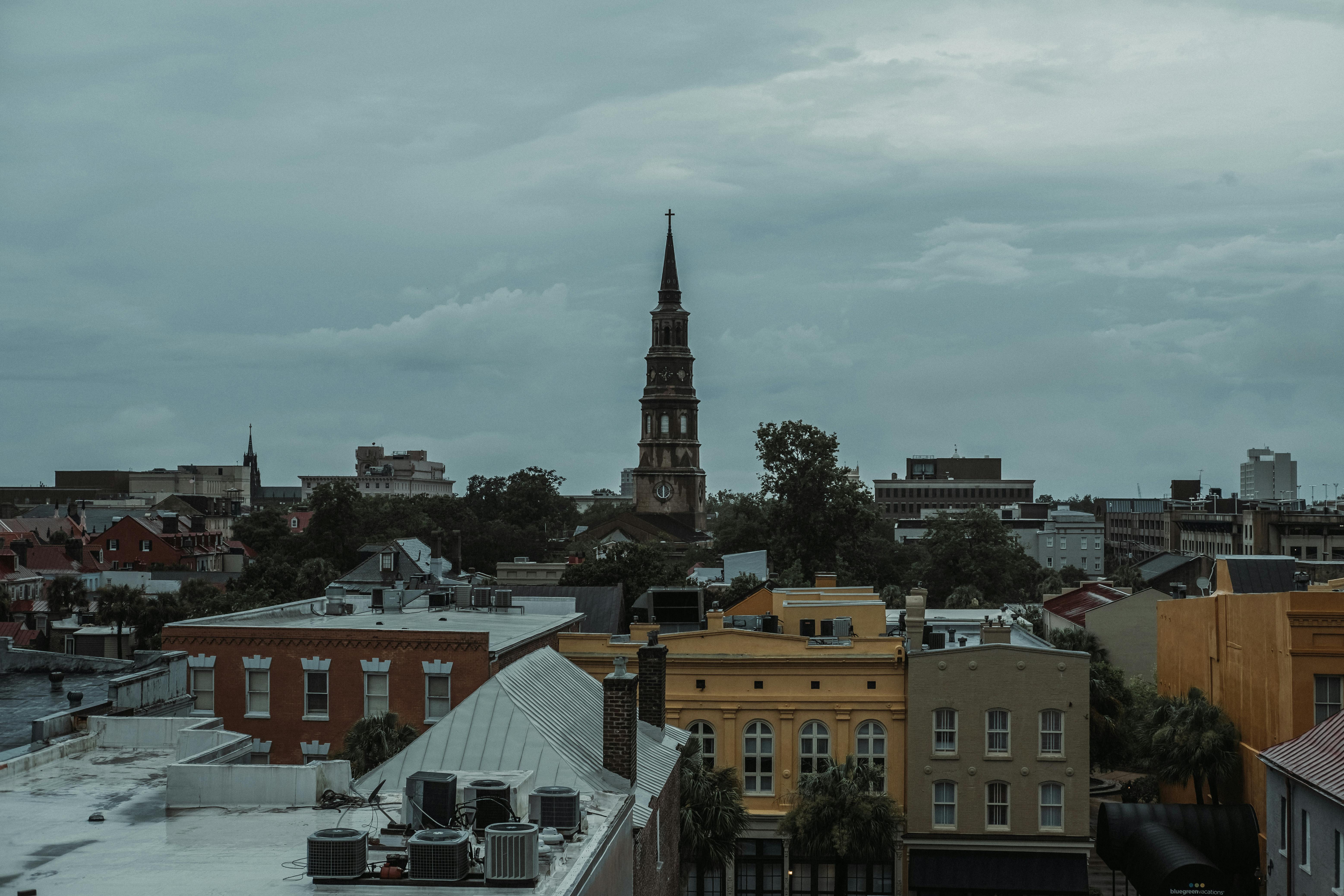 Captivating view of a historic bell tower amidst an urban cityscape under overcast skies.