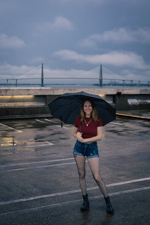 Woman in Denim Shorts Holding an Umbrella