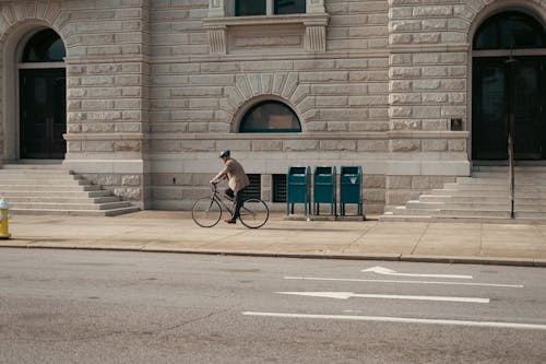 Man Riding a Bicycle Down the Sidewalk