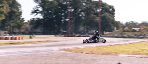 Free A go-kart racer speeds around a bend on an outdoor track, showcasing passion and skill. Stock Photo