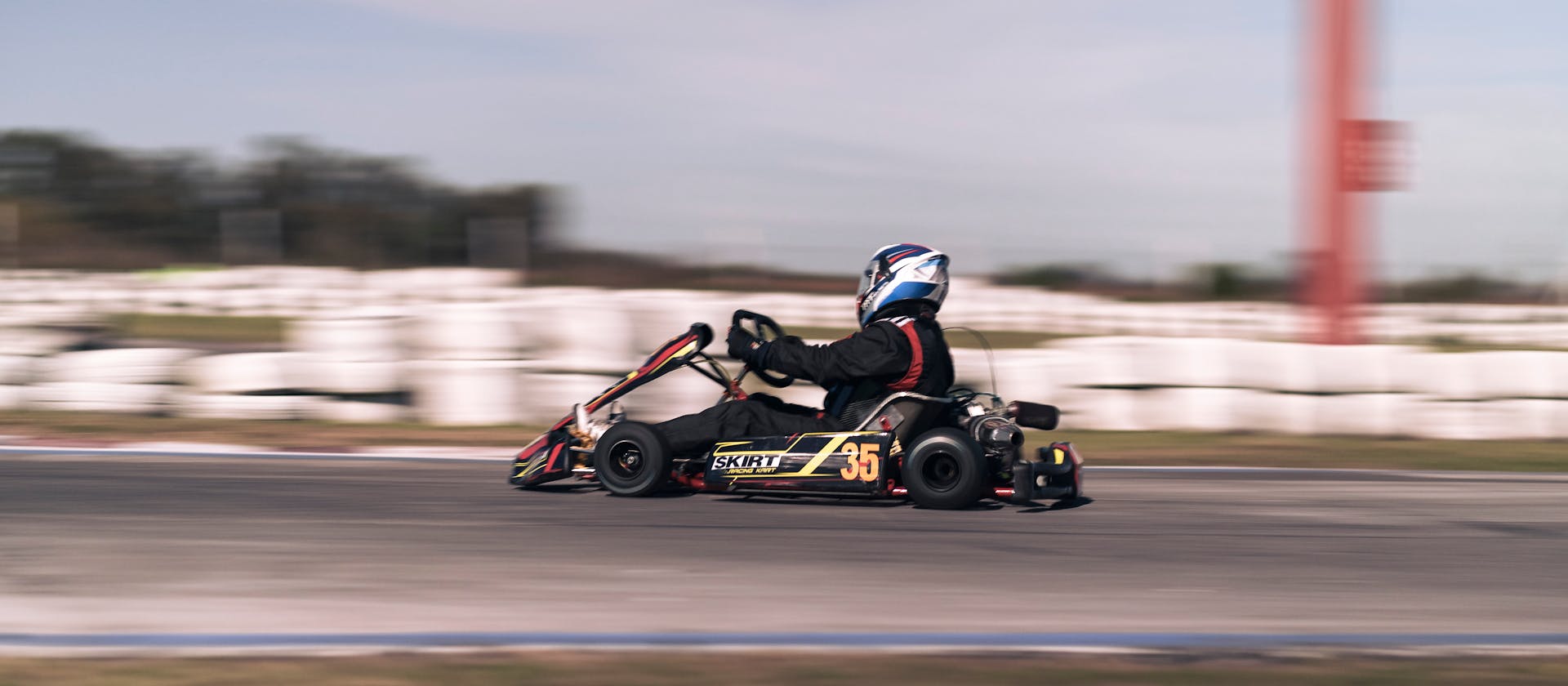 Capture the thrill of go-kart racing as a kart speeds around an outdoor track.