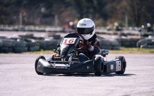 Free Experience high-speed go-kart racing on a sunny day, capturing the thrill of motorsport. Stock Photo
