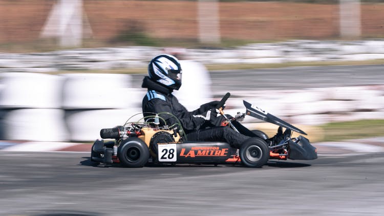 A Man Riding Go Kart On Race Track