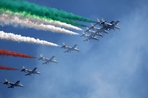 Free Frecce Tricolori jets perform stunning aerobatics with colorful smoke trails over Oggebbio, Italy. Stock Photo