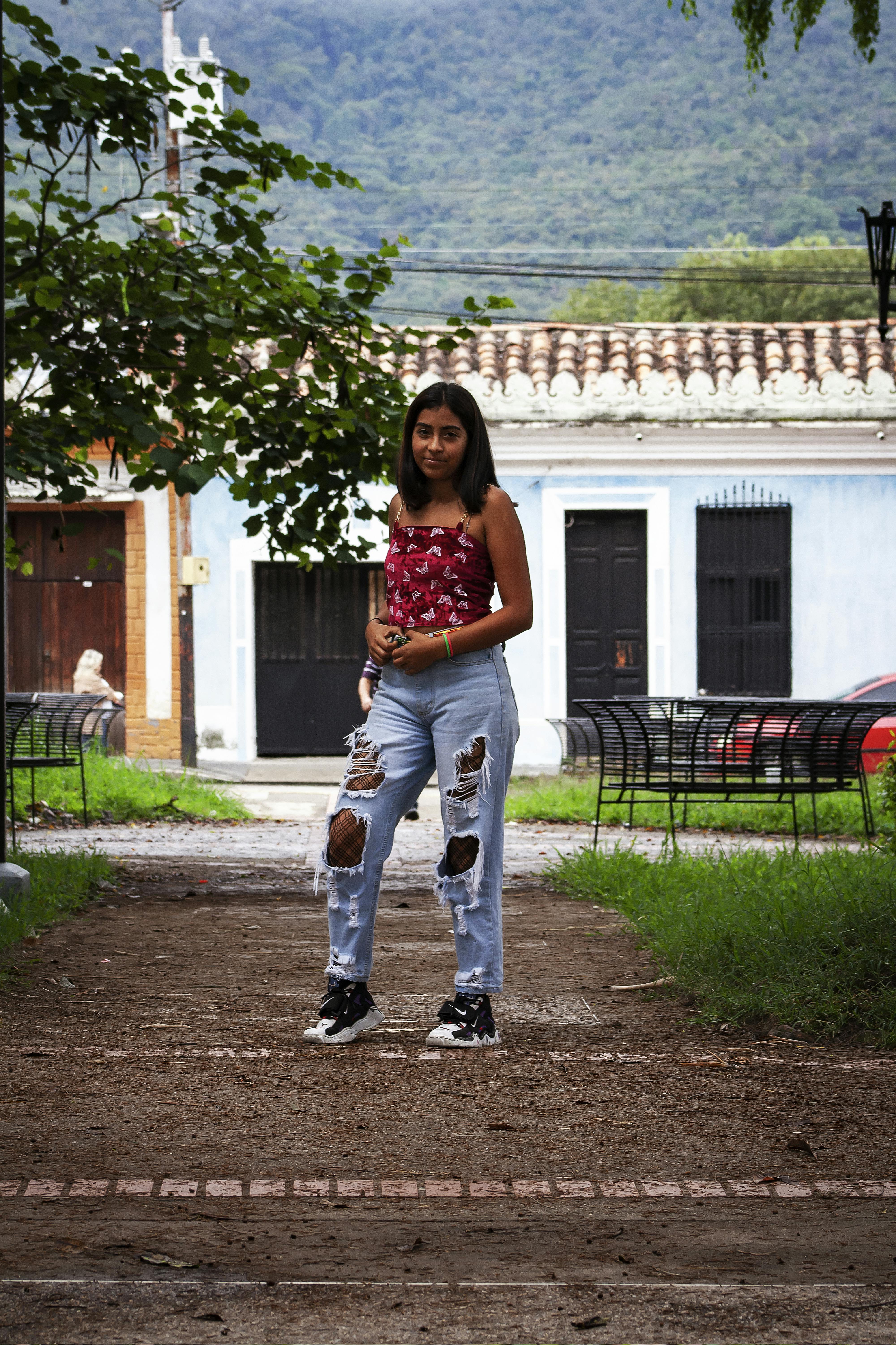 Young Brunette in Ripped Jeans · Free Stock Photo