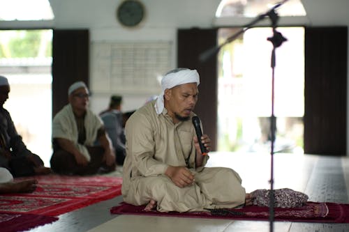 Man Chanting a Prayer on a Microphone