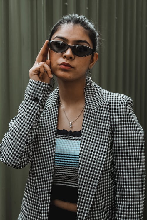 A Portrait of a Woman in a Plaid Jacket and Sunglasses