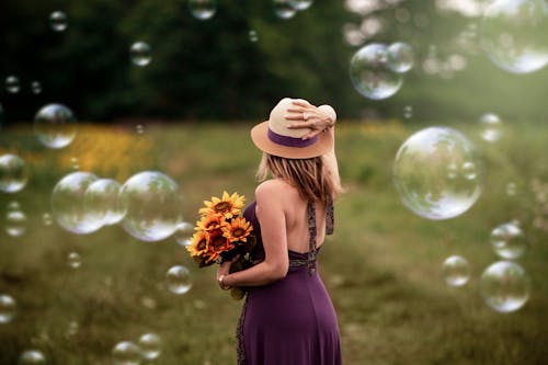 Woman Wearing Purple Dress Holding Sunflower