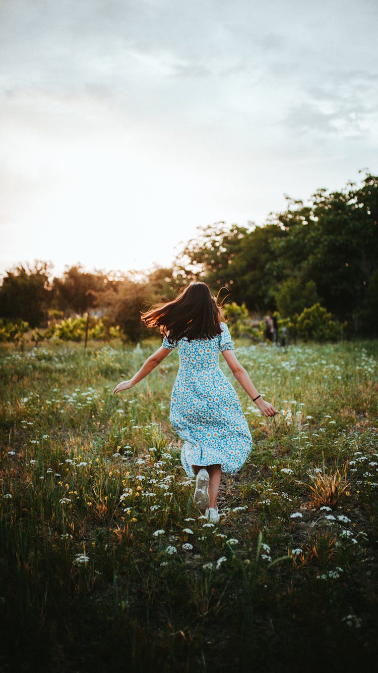 Back View Of A Girl In Floral Dress Running On Flower Field 