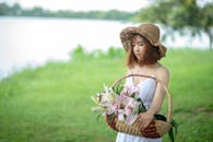 一个穿着白色连衣裙的女人，在湖边拿着一篮子百合花，形象宁静