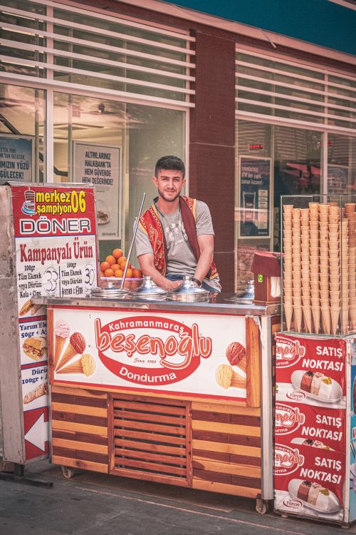 Free Turkish man in traditional attire selling ice cream at a street stand. Stock Photo