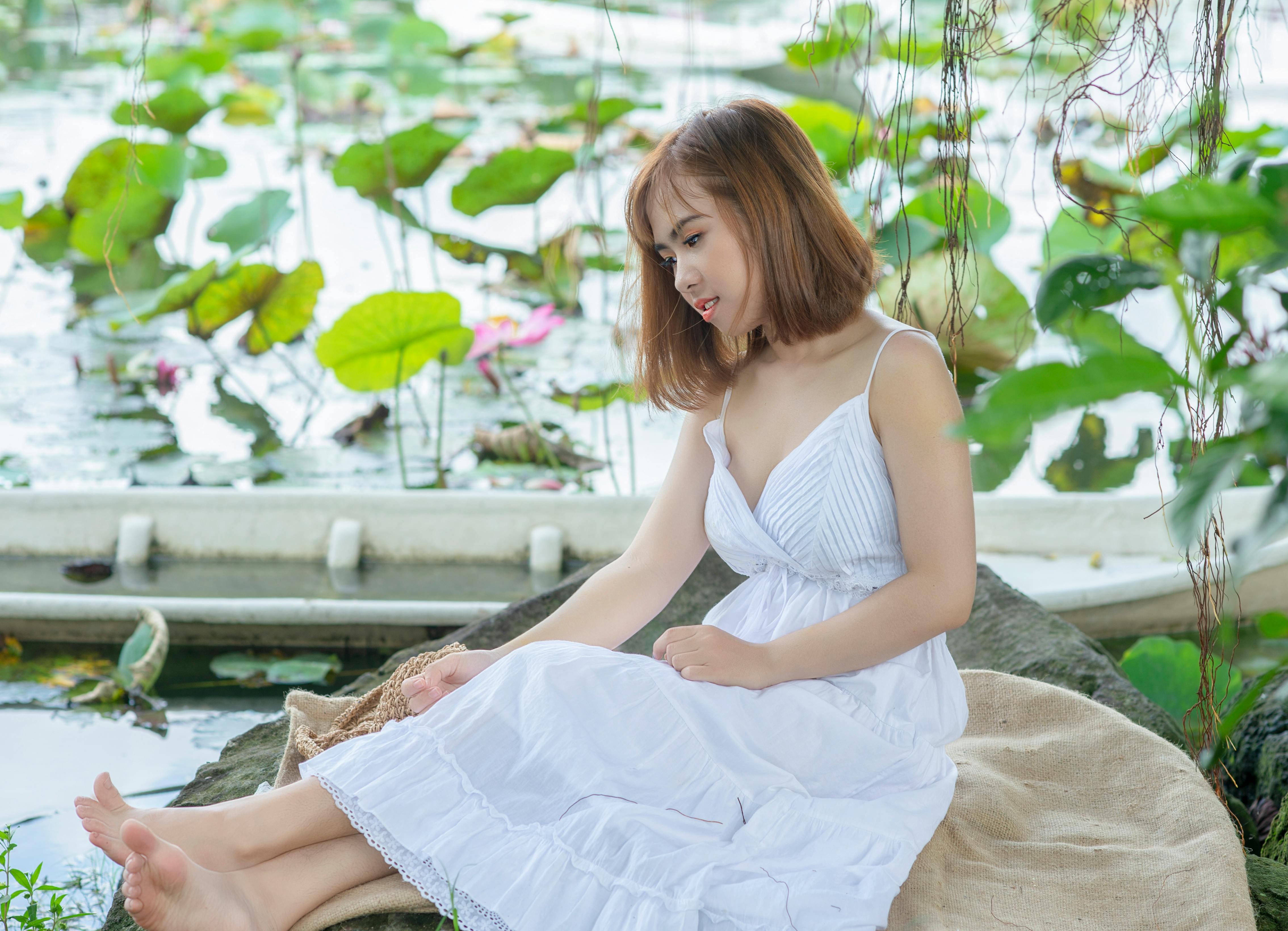 Gratis Wanita Yang Duduk Di Handuk Coklat Di Atas Batu Foto Stok