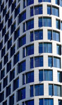Close-up of a modern high-rise building facade in Berlin with a curved design and reflective windows.