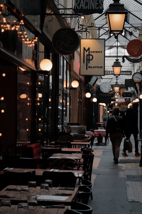 Free Explore the enchanting Passage des Panoramas in Paris, France, beautifully lit with vintage lamps at dusk. Stock Photo