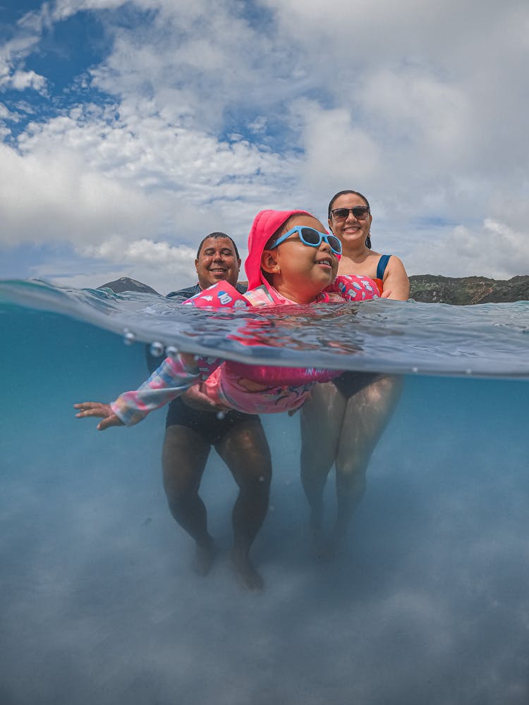 Family With Child Swimming In Water