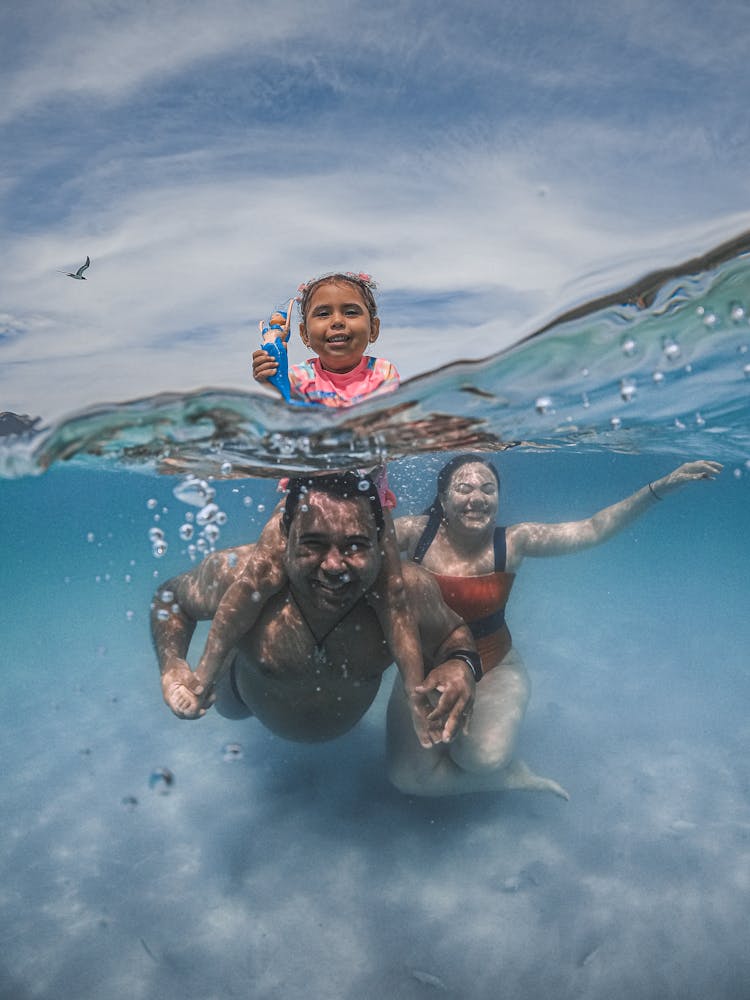 Parents With Child Swimming In Sea