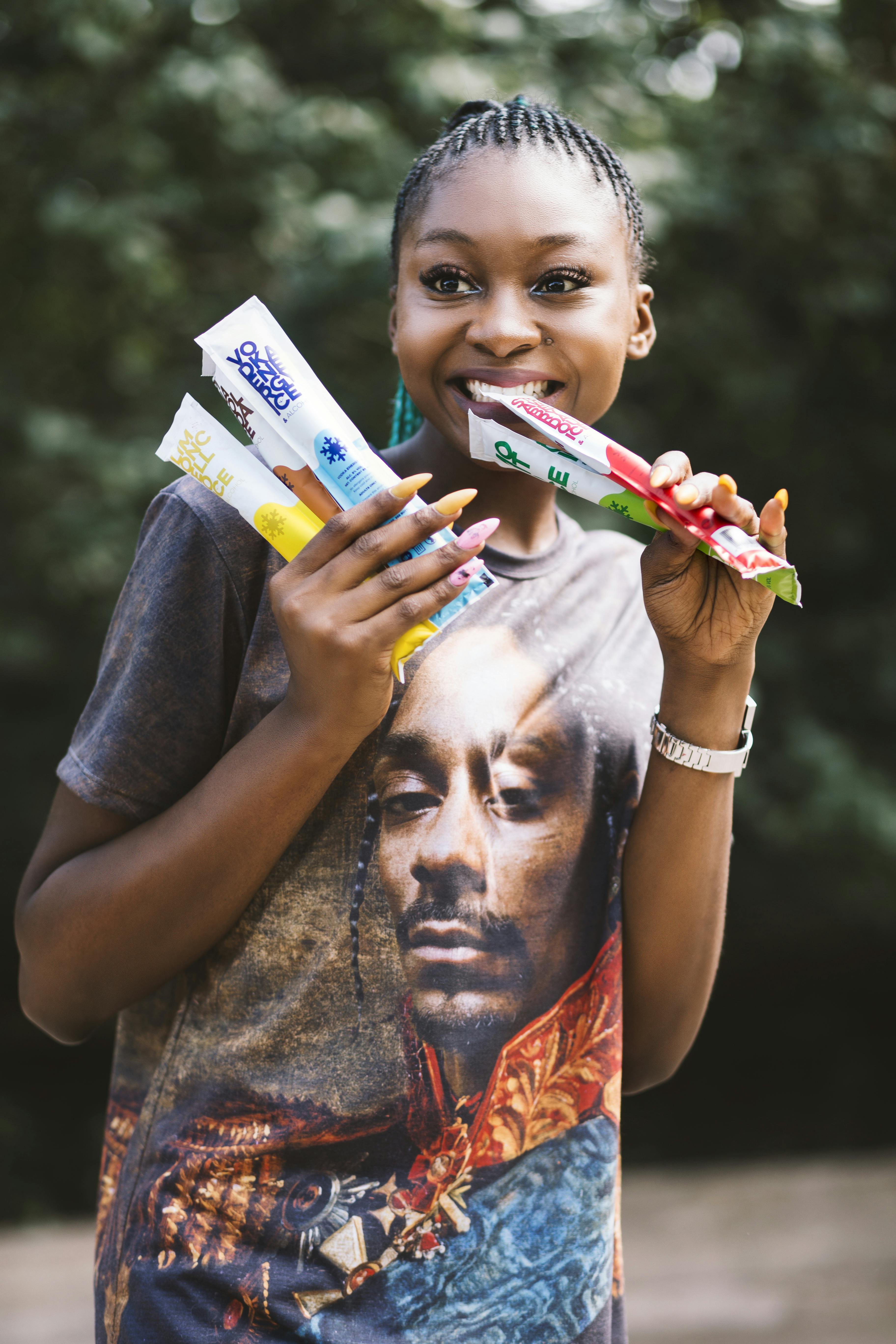 一位女士在户外俏皮地微笑着，享受着冰淇淋