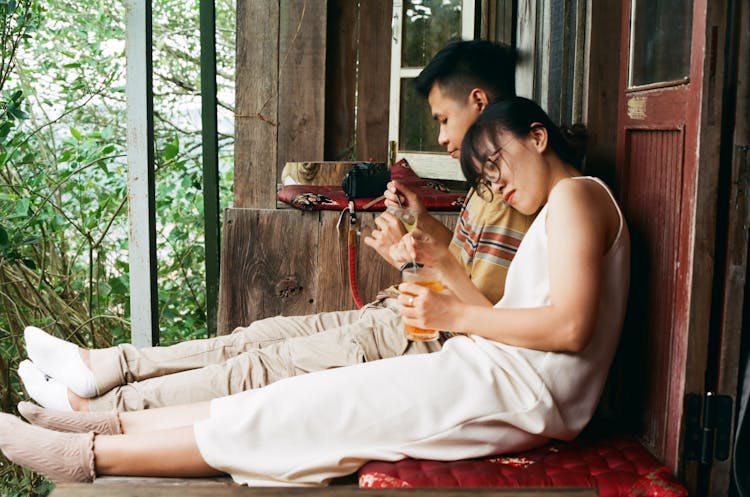 Young Couple Sitting Together On The Porch