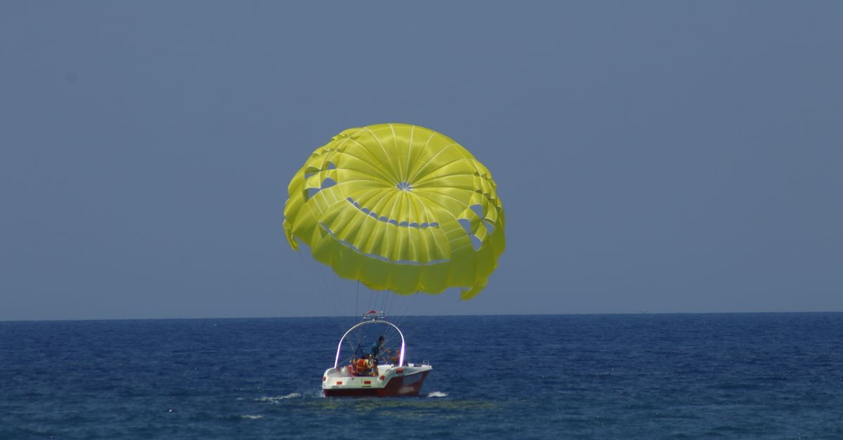 Experience the thrill of parasailing over the vast ocean, pulled by a speedboat.