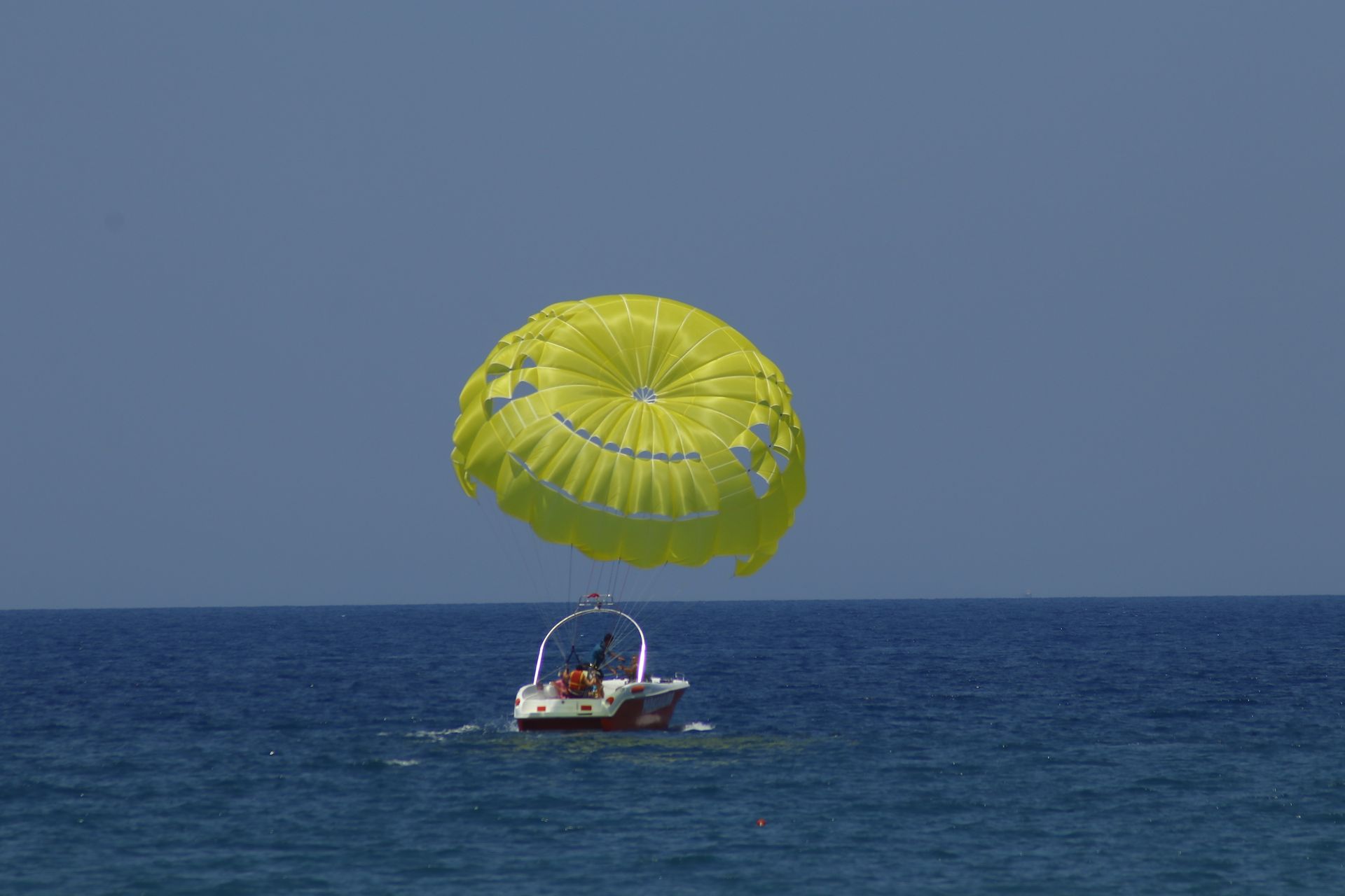 Experience the thrill of parasailing over the vast ocean, pulled by a speedboat.