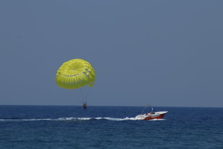 A Person Parasailing In The Ocean