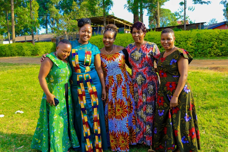 Women In Floral Dresses Stranding On Grass Field