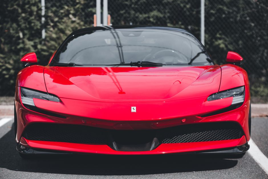Dynamic front view of a sleek red sports car showcasing design elegance and speed.