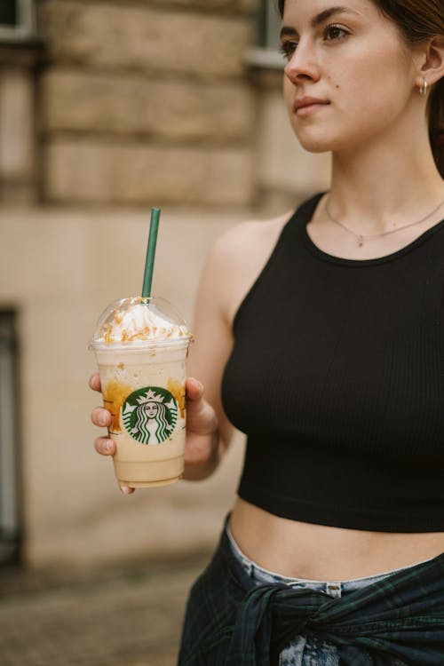 Free Woman in Black Tank Top Holding Starbucks Cup Stock Photo