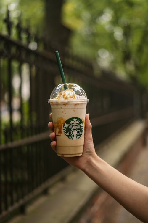 Person Holding a Starbucks Coffee Cup