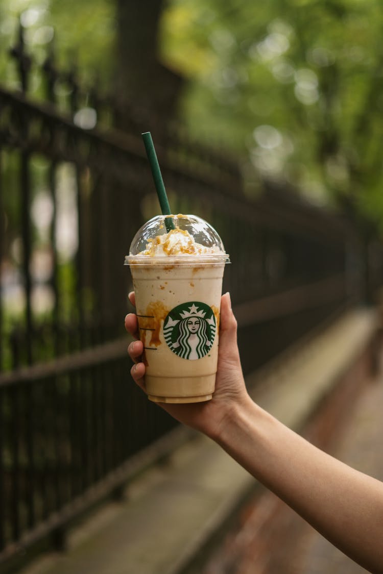 Person Holding A Starbucks Coffee Cup