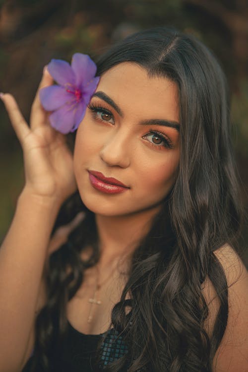 Beautiful Woman with Purple Flower on Ear
