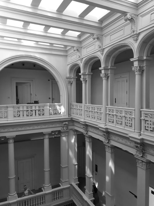 Free Explore a stunning neoclassical interior with arches, columns, and intricate detailing in this elegant black and white photograph. Stock Photo
