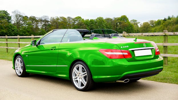 A green Mercedes Benz E220 convertible parked on a countryside road in the UK.