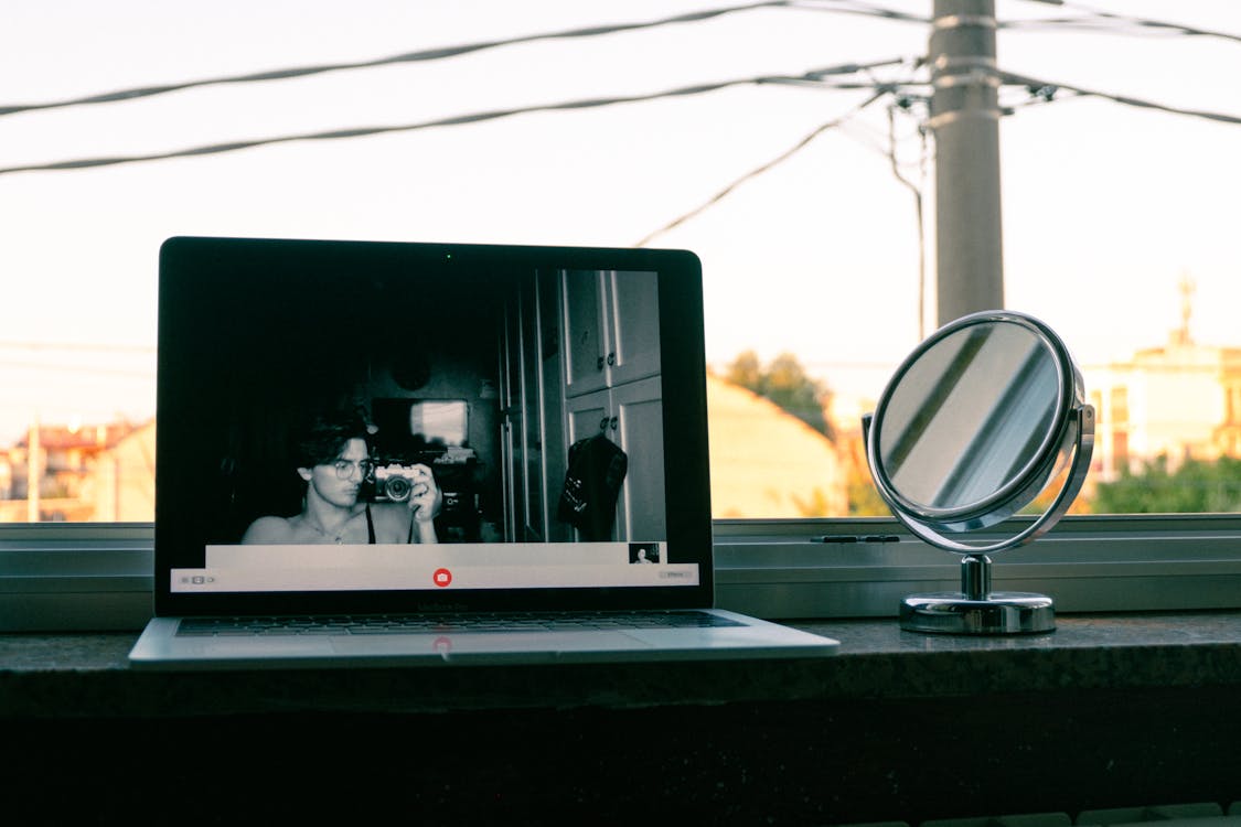 Person Taking Picture with Camera on Laptop Screen on Windowsill · Free ...
