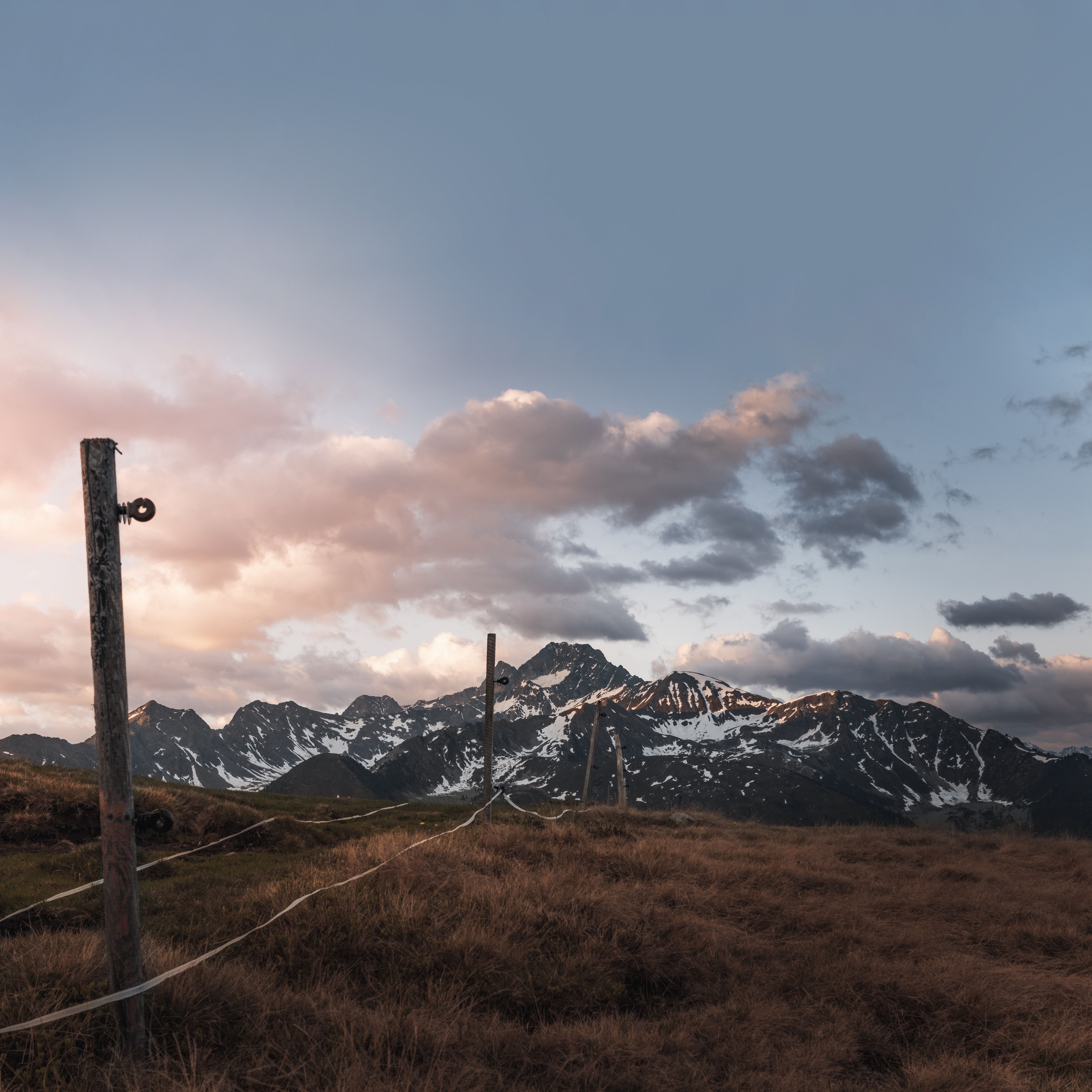 High voltage power lines against mountains in sunset · Free Stock Photo