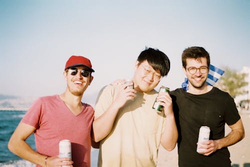 Men Holding Tins of Beer